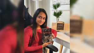 PhD in Education student Ms Jennifer Sheokarah with her new book The Intruder.